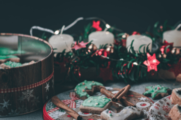 Assorted Christmas cookies in tins with candles and lights