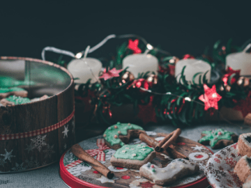 Assorted Christmas cookies in tins with candles and lights