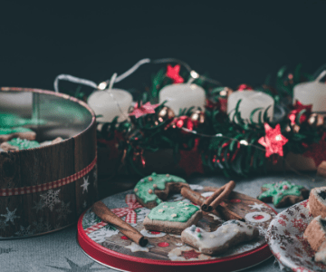 Assorted Christmas cookies in tins with candles and lights