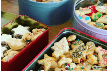 Many cut-out Christmas cookies in tins