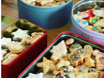 Many cut-out Christmas cookies in tins