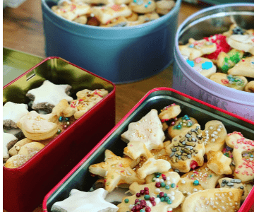 Many cut-out Christmas cookies in tins