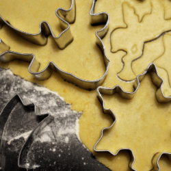 Christmas cookies being cut out of dough