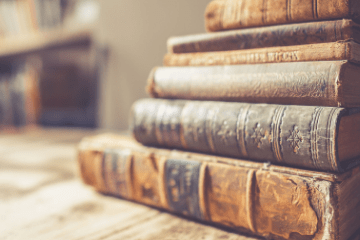 stack of old books on a wooden surface