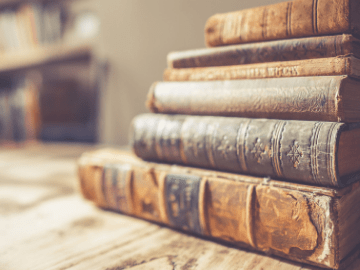 stack of old books on a wooden surface