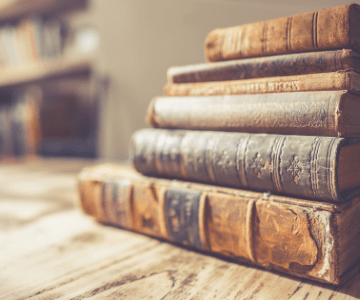 stack of old books on a wooden surface